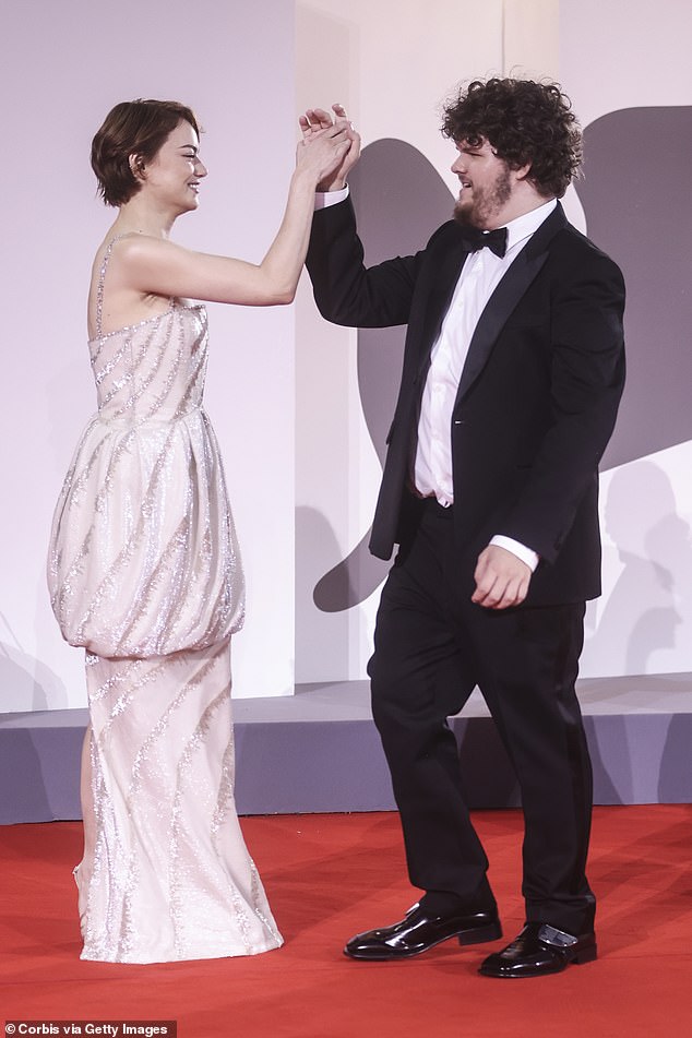 Emma had fun on the red carpet as she shook hands with her co-star Aidan ahead of the premiere