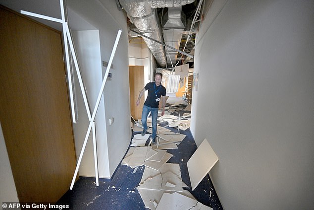 An EU employee walks in the debris after the strike. Several EU officials have blasted the attack saying it was 'deliberate'