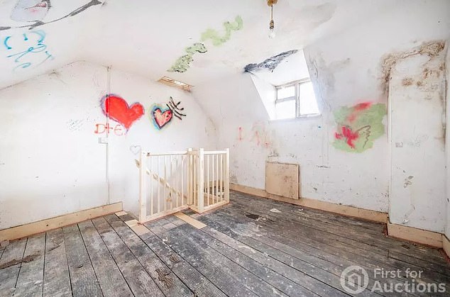 The attic of the home (pictured) is seemingly less affected by the apparent black mould - but it is covered in graffiti and what appear to be damp patches instead