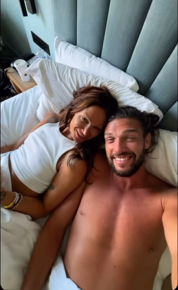 Andy Carroll and Lou Teasdale cuddling in bed.