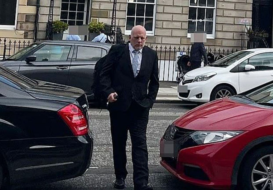 Man in suit walking down a street.