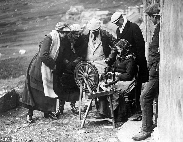 Visitors to St Kilda watch as a resident demonstrates the art of spinning, 1926