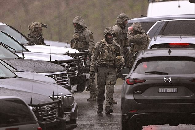Heavily armed police gather at a staging point during a search for a fugitive linked to the murder of two police officers, in Porepunkah on August 29, 2025. Australian police said on August 28, that they will not rest until they catch a 56-year-old gunman who fled into the bush two days earlier after allegedly killing two officers. Detectives said they were speaking to the man's partner and searching rugged, forested terrain near the small town of Porepunkah, in the northeast of Victoria state. (Photo by William WEST / AFP) (Photo by WILLIAM WEST/AFP via Getty Images)