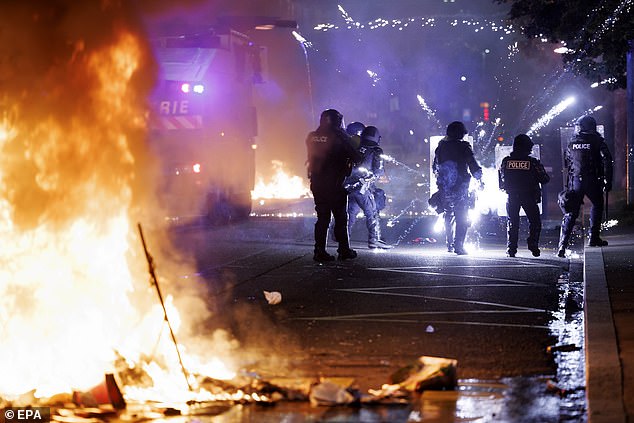 Police officers intervene during the second night of riots following the fatal accident involving a minor on a scooter in Lausanne, Switzerland, 25 August 2025