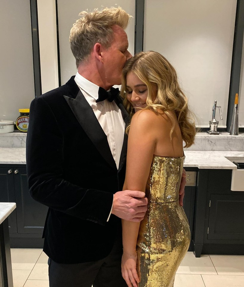 A man in a tuxedo kisses a woman on the forehead.