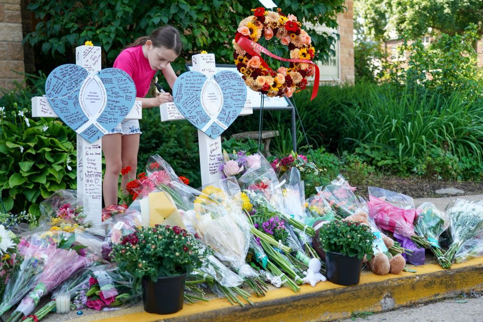 Memorial with flowers and candles honoring shooting victims.