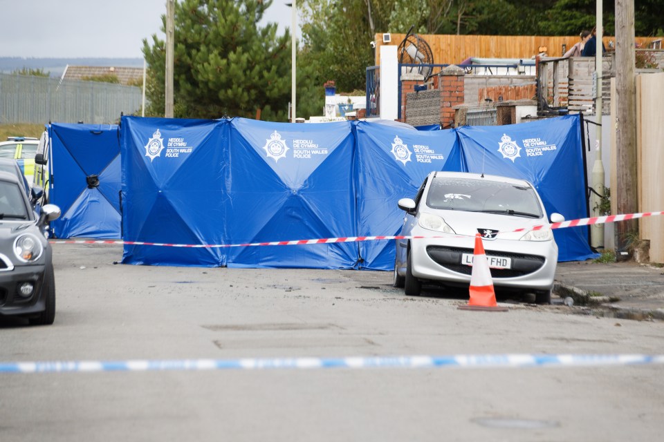 Crime scene: a body was found in a burned car behind a police screen.