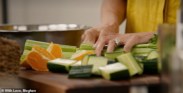 In the kitchen, while chopping cucumbers, lime, orange and celery, Meghan added: 'But then again, I haven't done it in 20 years'