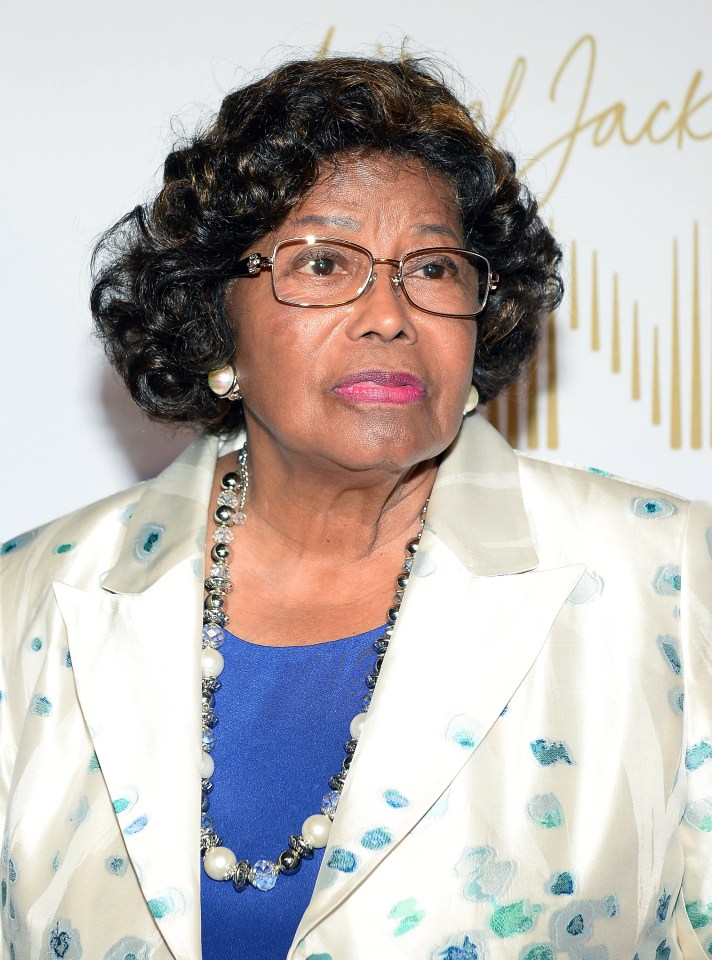 Katherine Jackson in a wheelchair, assisted by a nurse.