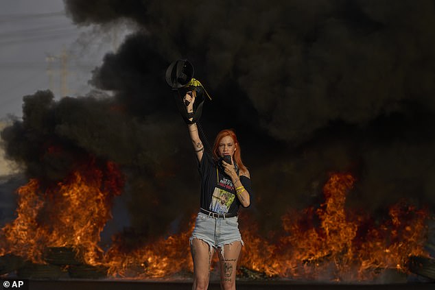 An activist blocks a highway during a protest demanding the immediate release of hostages held by Hamas and calling for the Israeli government to reverse its decision to take over Gaza City on Tuesday, August 26, 2025