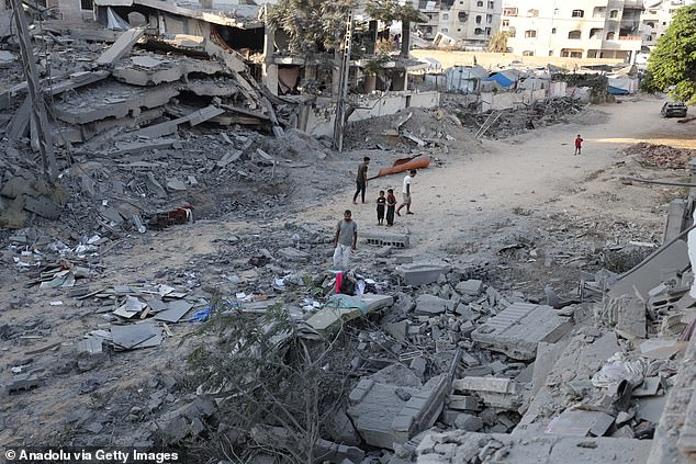 Palestinians gather at the scene to inspect the aftermath of the Israeli attack in Gaza City on August 29, 2025