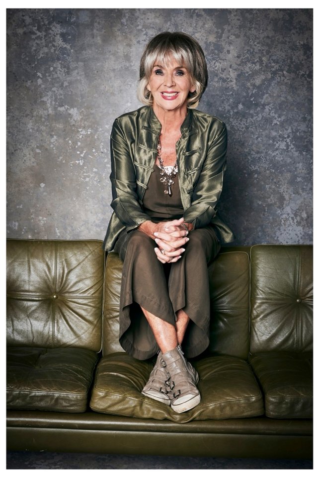 Sue Johnston, actress, sitting on a couch.