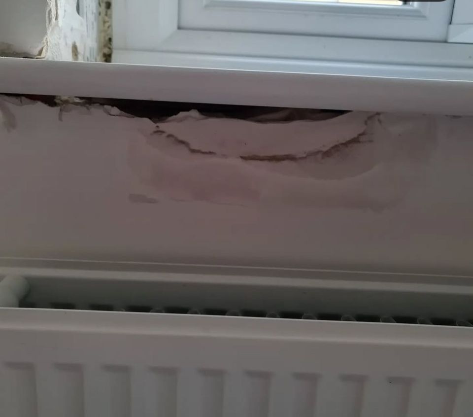 Damaged wall below a window.