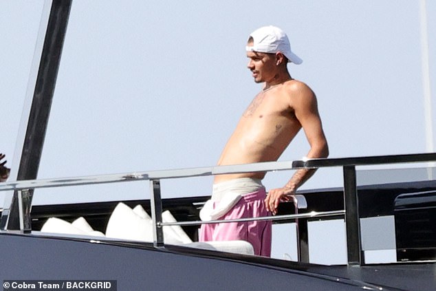 Romeo looked in great spirits as he set to work topping up his tan on the holiday