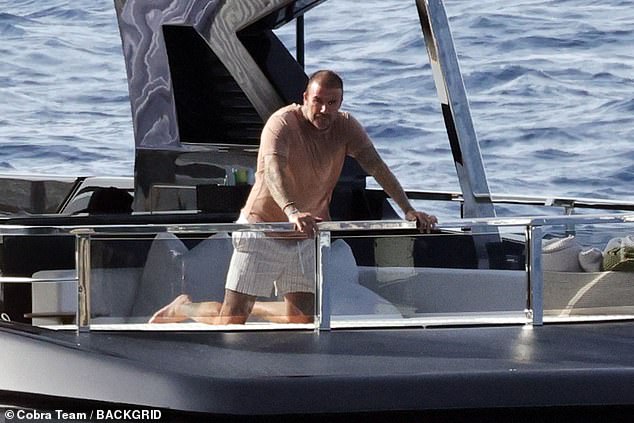 David later layered up in a tan T-shirt teamed up white striped shorts