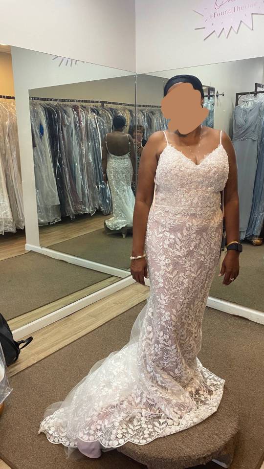 Woman in a lace wedding dress in a bridal shop.