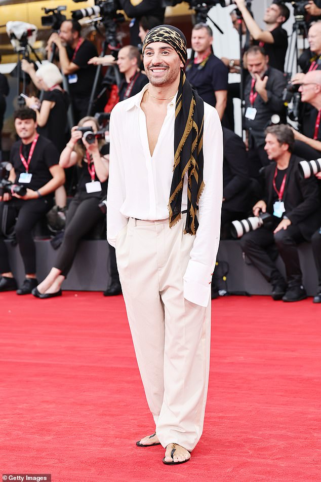 Stefano Guerrera cut a relaxed figure as he stepped out in black sandals and accessorised his white ensemble with a black and gold scarf wrapped around his head
