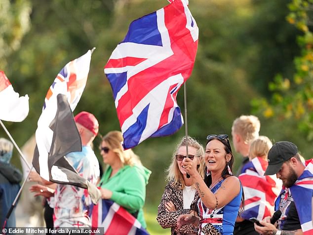 A woman waves a union jack flag outside of the Park Hotel in Chichester today as they protest outside The Park hotel