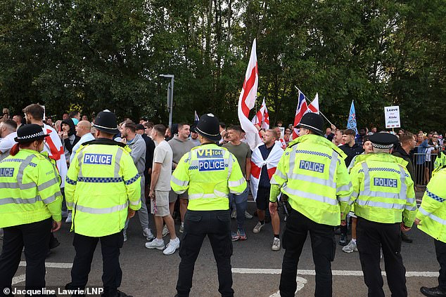 Anti-immigration Protesters block the road as Police attempt to hold them back, outside The Delta Marriott Hotel today
