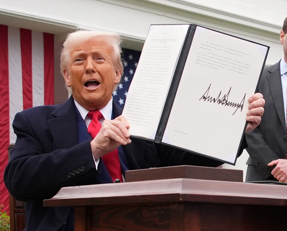 President Trump holding a signed executive order.