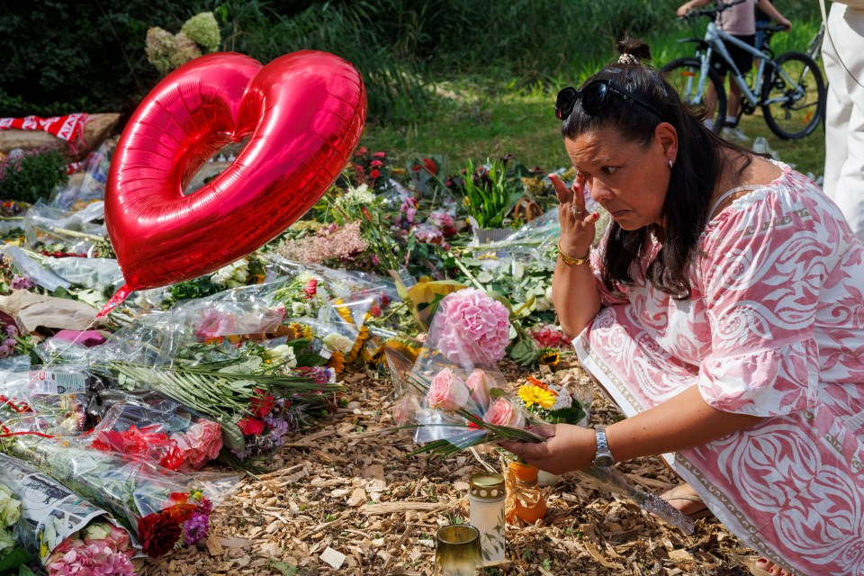 Woman laying flowers at a memorial.