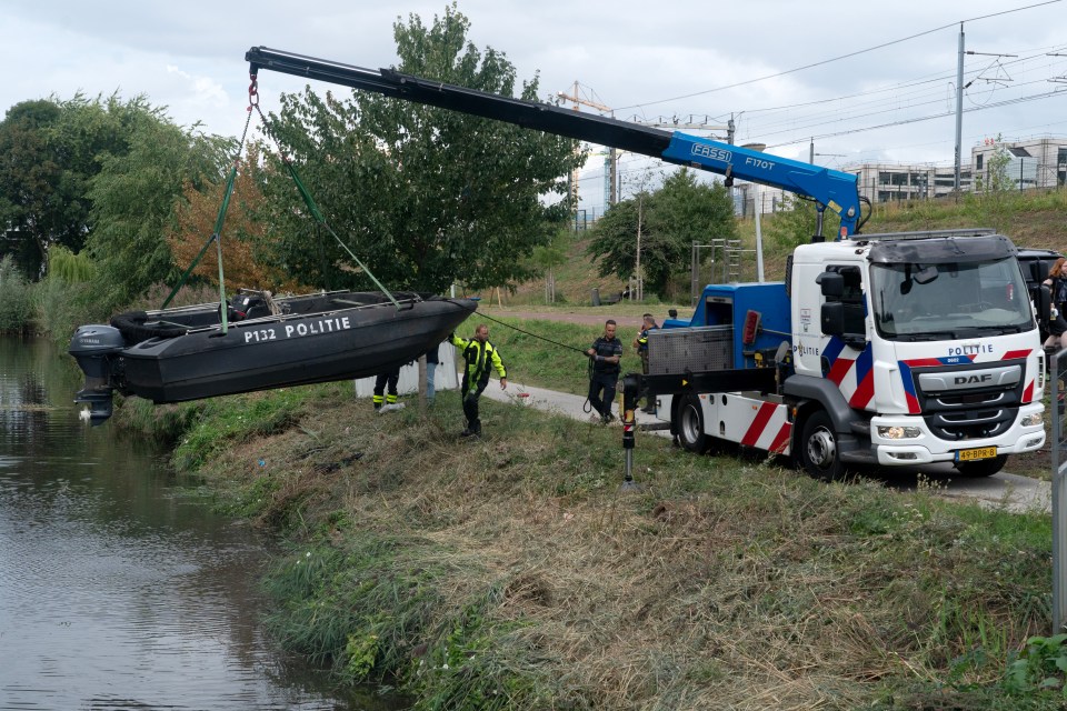 Police retrieving a boat from a canal.