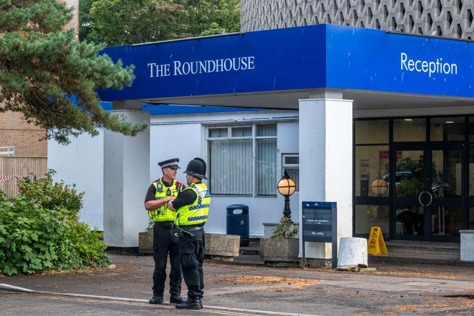 Two police officers standing outside The Roundhouse hotel.