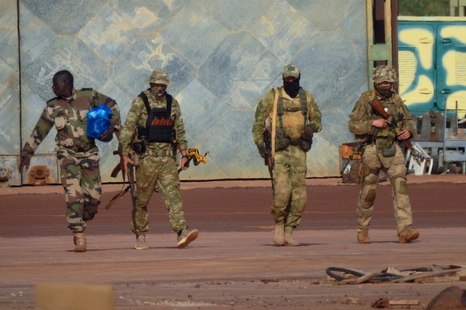 Four armed mercenaries walking in northern Mali.