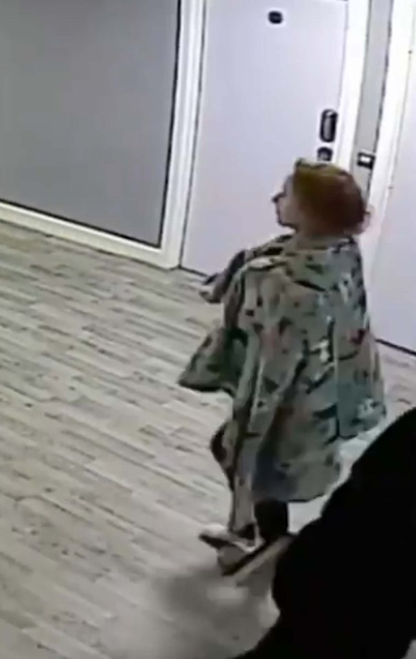 CCTV footage of a young woman walking in a hospital corridor.