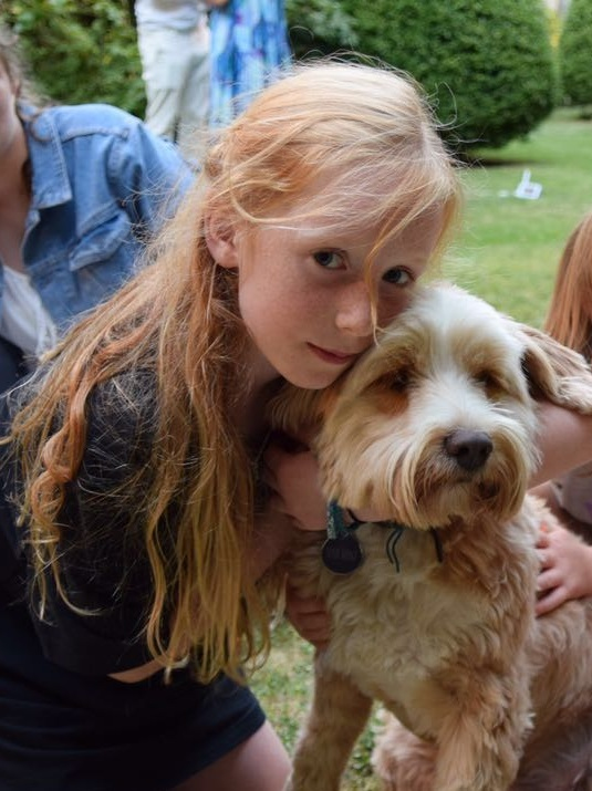 Photo of Ruth Szymankiewicz hugging a dog.