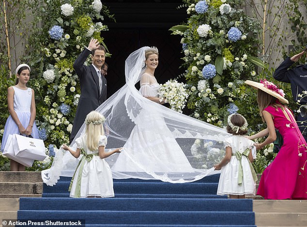 The newlyweds couldn't conceal their joy at tying the knot, and were seen beaming and waving at the assembled crowds