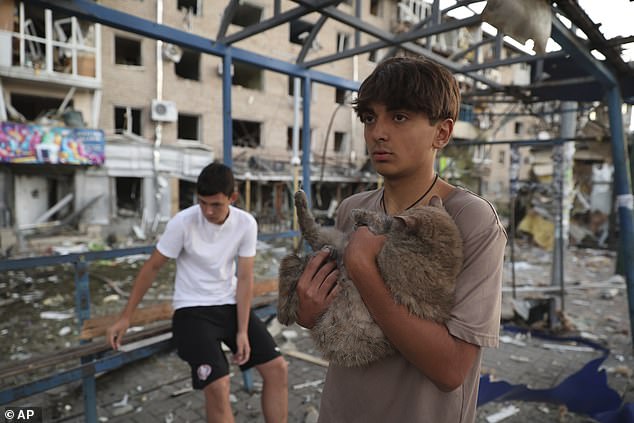 A local resident carries his pet after Russian air strike that destroyed residential neighbourhood in Zaporizhzhia, Ukraine, Saturday, Aug. 30, 2025
