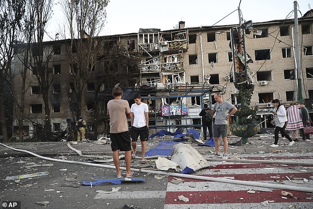 Local residents stand near their destroyed home following Russian air strike in Zaporizhzhia, Ukraine, Saturday, Aug. 30, 2025