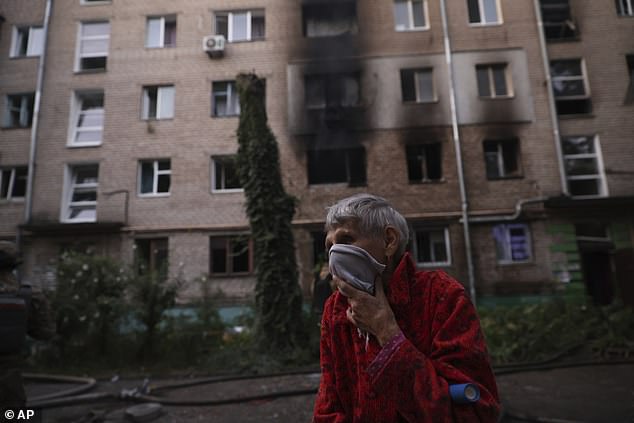 A local resident carries his pet after Russian air strike that destroyed residential neighbourhood in Zaporizhzhia, Ukraine, Saturday, Aug. 30, 2025