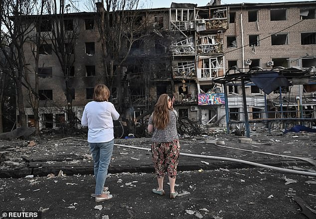 Residents stand at the site of an apartment building hit during a Russian drone and missile strike, amid Russia's attack on Ukraine, in Zaporizhzhia, Ukraine August 30, 2025