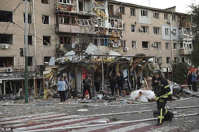 Local residents look at their destroyed home following Russian air strike in Zaporizhzhia, Ukraine, Saturday, Aug. 30, 2025