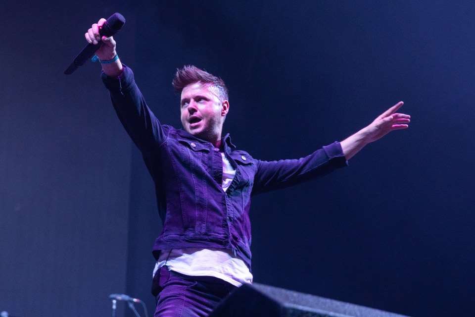 Lee Brennan of 911 performing at a concert.
