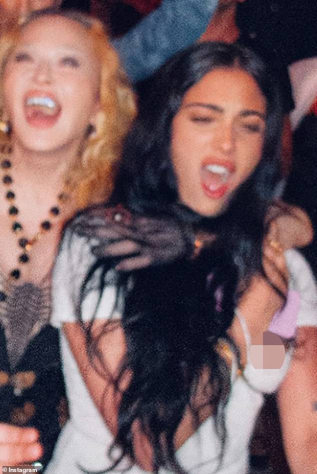 Standing behind Lourdes, Madonna wrapped her arm around her daughter's shoulders but seemingly and accidentally pulled the neckline of her dress dangerously low