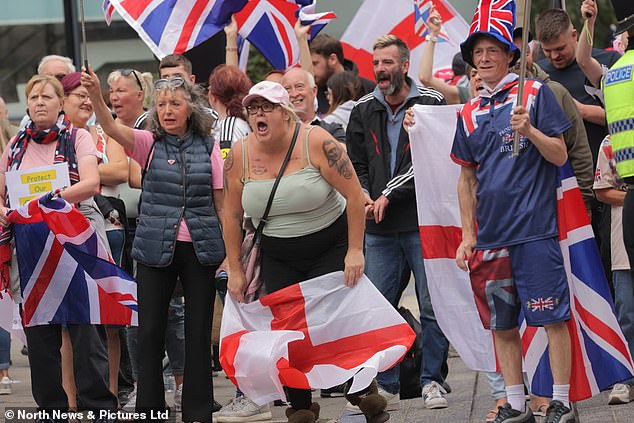 A protester displays a tattoo of Tommy Robinson on her arm as rival protest groups clash outside the New Bridge Hotel in Newcastle