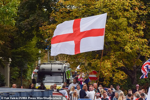 Crowds of anti-migrant demonstrators holding English flags and Union Jacks gather outside the Crowne Plaza hotel in West Drayton