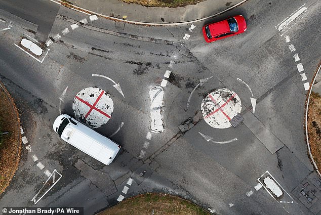 St George's crosses painted over two mini roundabouts at the junction of Hitcham Lane and Gore Road in Taplow, Berkshire