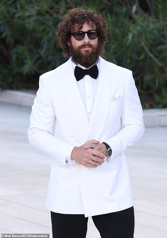 Aaron looked dapper in a white and black suit, with a bow-tie and a pair of sunglasses