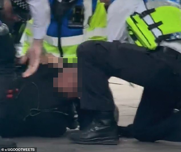 While police held the boy's face to the ground they placed him in handcuffs outside a nearby tube station