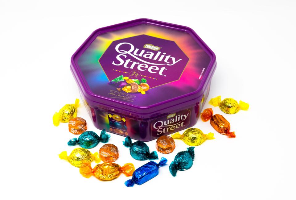 Purple Quality Street chocolate container with assorted chocolates.