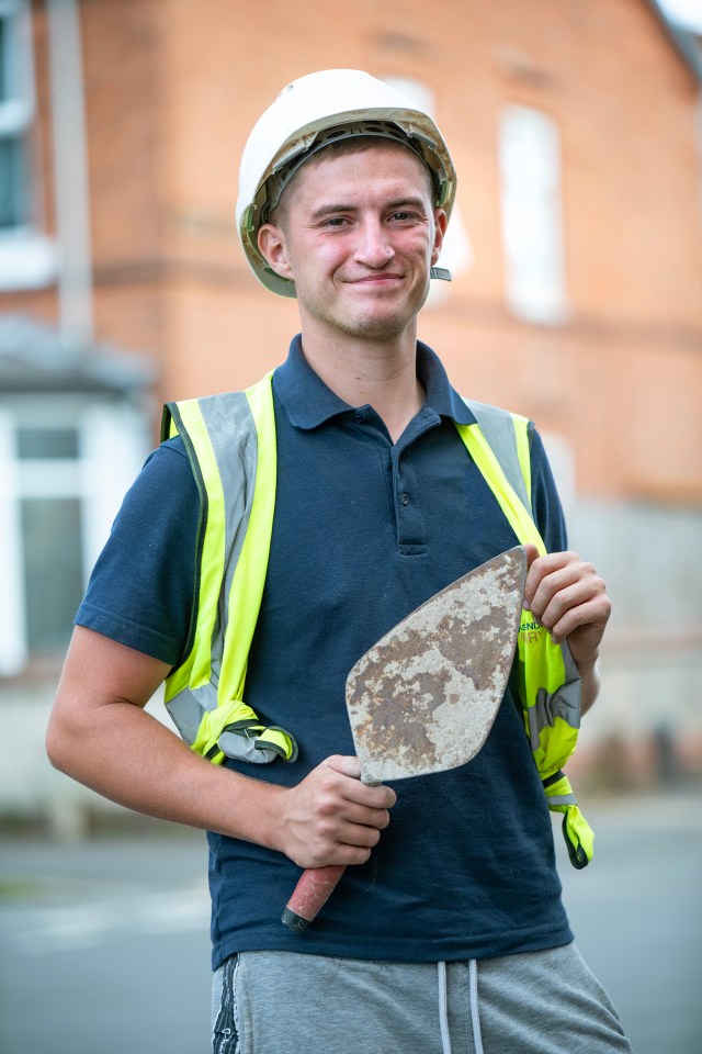 Portrait of a young bricklayer holding a trowel.