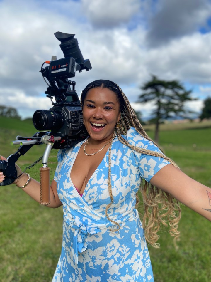 Woman holding a camera and smiling.