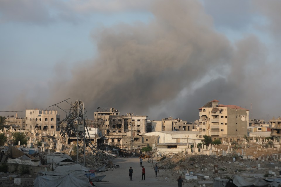 Smoke rises over damaged buildings and a cemetery in Gaza City after airstrikes.