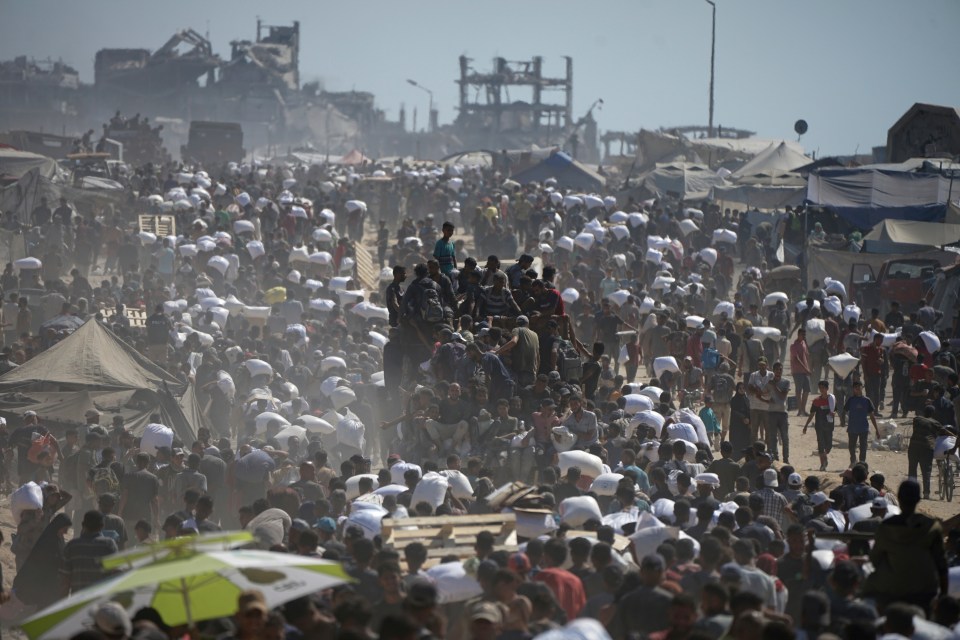 Palestinians carrying sacks of flour from a humanitarian aid convoy in Beit Lahiya, Gaza.