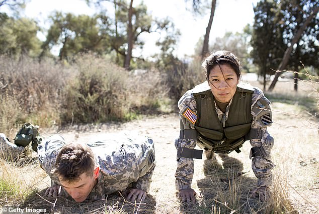 The new fitness trend inspired by military conditioning is a throwback to military rucking and athletic training. Pictured: A US Army man and woman wear weighted vests while doing pushups in a field