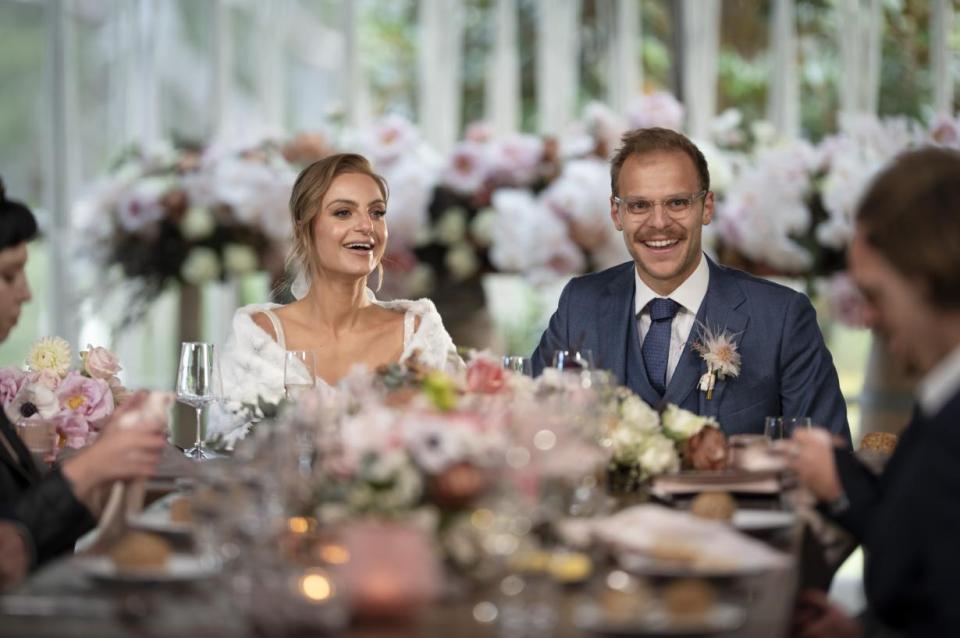 Bride and groom laughing at wedding reception.